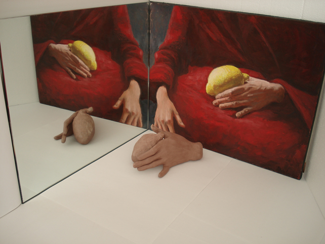 Painting of hands holding a lemon, next to a sculpture of a hand holding a lemon.